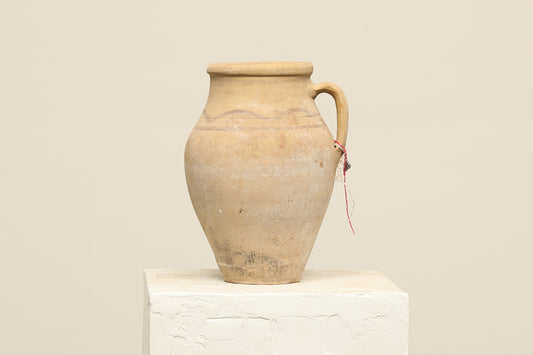 A one-of-a-kind natural Turkish vintage vase pot with a handle, crafted from terra cotta clay, this piece showcases timeless quality and antique craftsmanship, adding a unique touch of history to your space