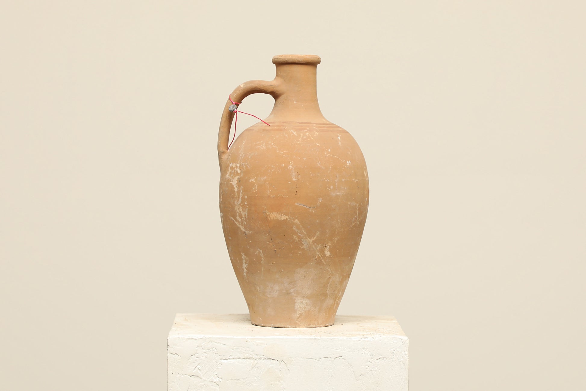 A one-of-a-kind natural Turkish vintage vase pot with a handle, crafted from terra cotta clay, this piece showcases timeless quality and antique craftsmanship, adding a unique touch of history to your space