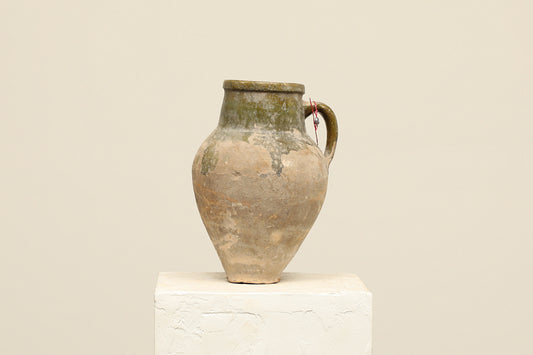 A one-of-a-kind natural Turkish vintage vase pot with a handle, crafted from terra cotta clay, this piece showcases timeless quality and antique craftsmanship, adding a unique touch of history to your space