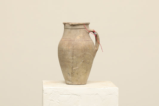 A one-of-a-kind neutral Turkish vintage vase pot with a handle, crafted from terra cotta clay, this piece showcases timeless quality and antique craftsmanship, adding a unique touch of history to your space