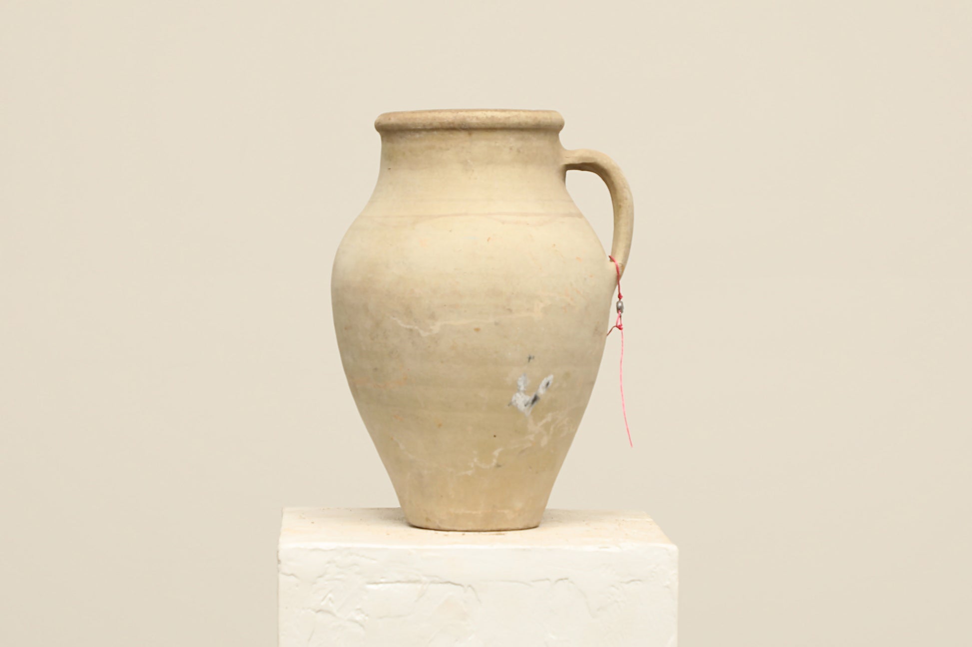 A one-of-a-kind neutral Turkish vintage vase pot with a handle, crafted from terra cotta clay, this piece showcases timeless quality and antique craftsmanship, adding a unique touch of history to your space