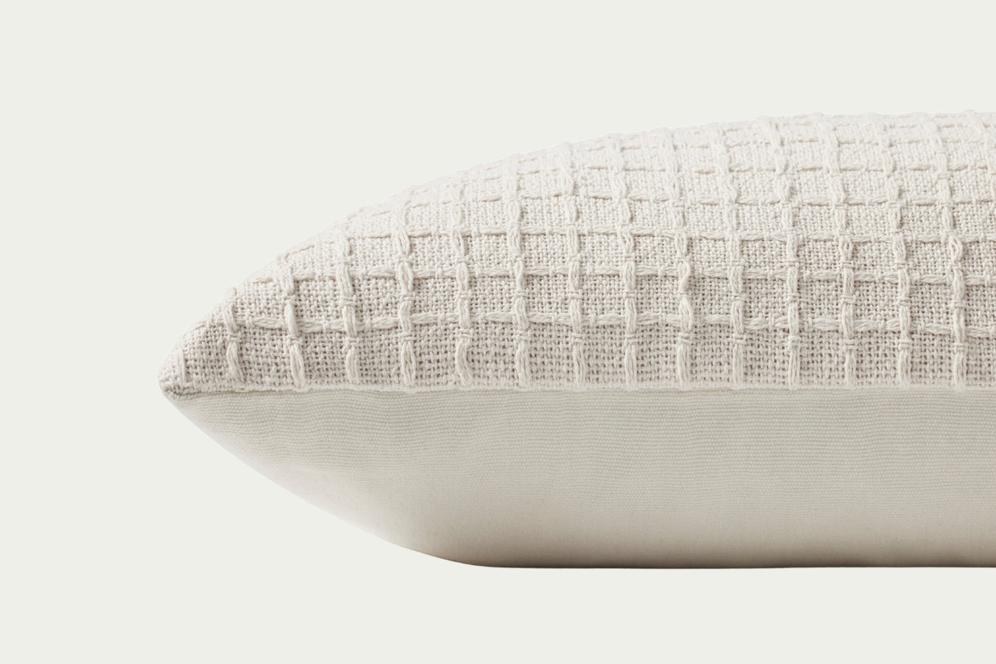 This clean ivory modern throw pillow features a stitched grid design for a hint of texture. The accent pillow cover is made of cotton and measures 12-inches by 27-inches, an elongated size to style in living rooms and bedrooms.