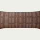 Geometric embroidery that draws the eye toward it. In Clay and Mist, a warm neutral brown with off-white details in a 35-inch by 13-inch rectangular throw pillow.