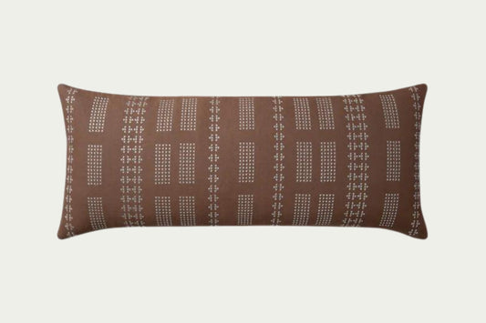 Geometric embroidery that draws the eye toward it. In Clay and Mist, a warm neutral brown with off-white details in a 35-inch by 13-inch rectangular throw pillow.