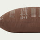 Geometric embroidery that draws the eye toward it. In Clay and Mist, a warm neutral brown with off-white details in a 35-inch by 13-inch rectangular throw pillow.