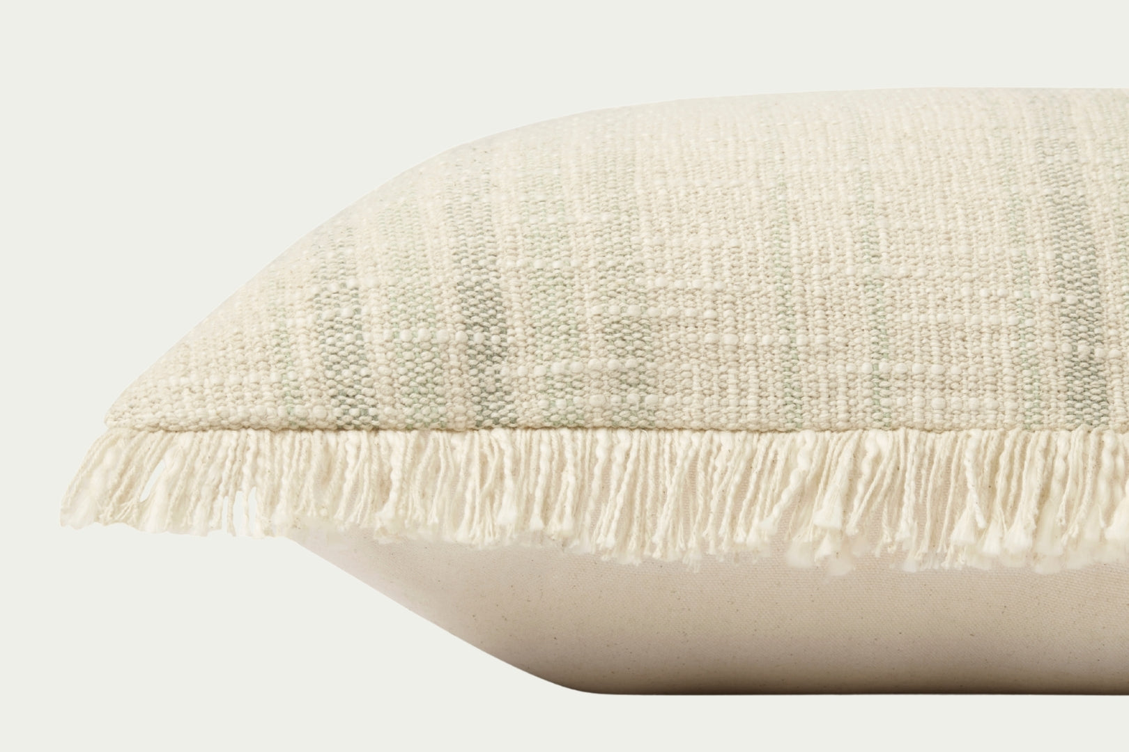 Modern throw pillow features a timeless pattern in an ivory and sage palette in a textural boucle with fringe trim on two sides.